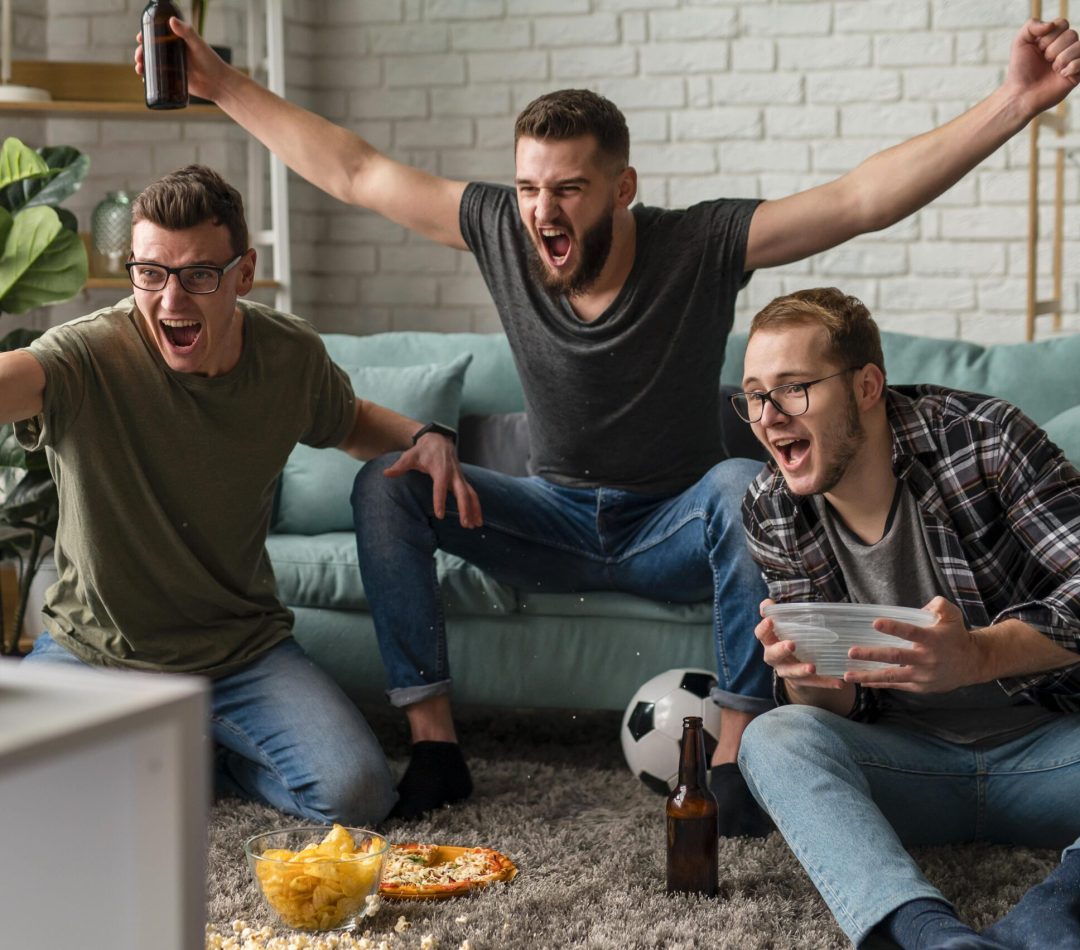 front-view-cheerful-male-friends-watching-sports-tv-together-while-having-snacks-beer (1)